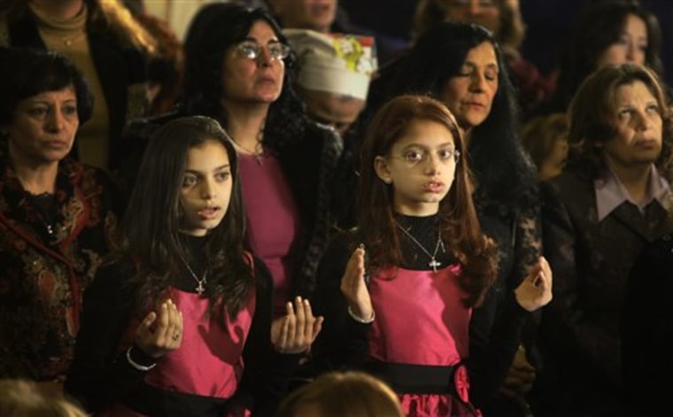 Coptic Christian girls pray during Christmas Eve Mass at the Coptic cathedral in Cairo, Egypt, Thursday, Jan. 6, 2011. Egyptian authorities put up a heavy security cordon around the Coptic cathedral in Cairo hours before Christmas Eve Mass, using bomb-sniffing dogs, metal detectors and officers to try to prevent another attack like the New Year's suicide bombing of a church in Alexandria that killed 21 people. (AP Photo/Ben Curtis)